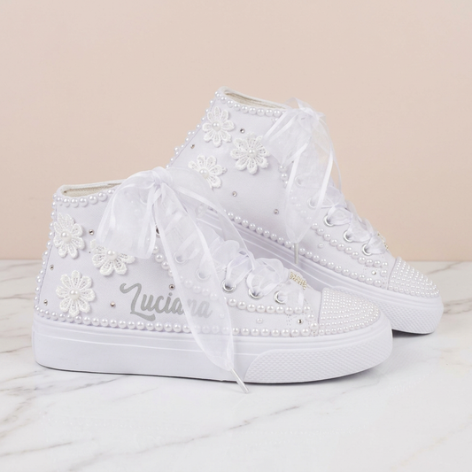 Tenis blancos con flores y perlas - vista lateral sobre mármol